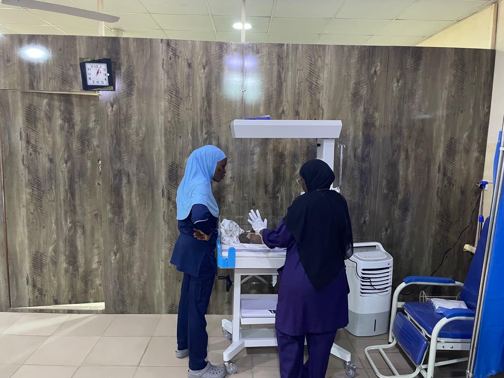 A nurse learning about newborn resuscitation from a doctor