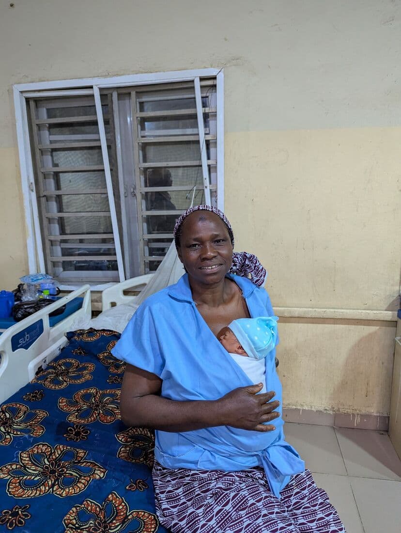 A mother on the ward in Kano holding her newborn against her chest