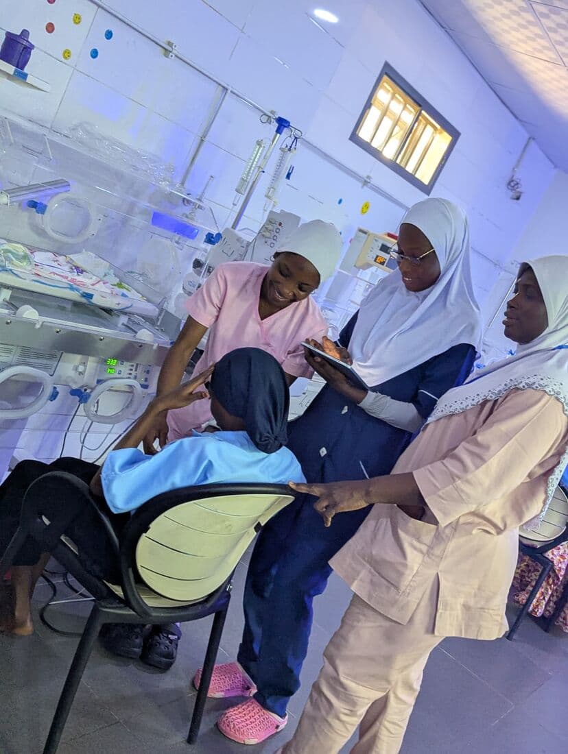 Nurses at the incubator bay going through a newborn's chart with the mother