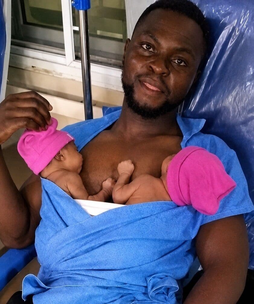 A father holding his newborn twins against his chest in Kangaroo Care