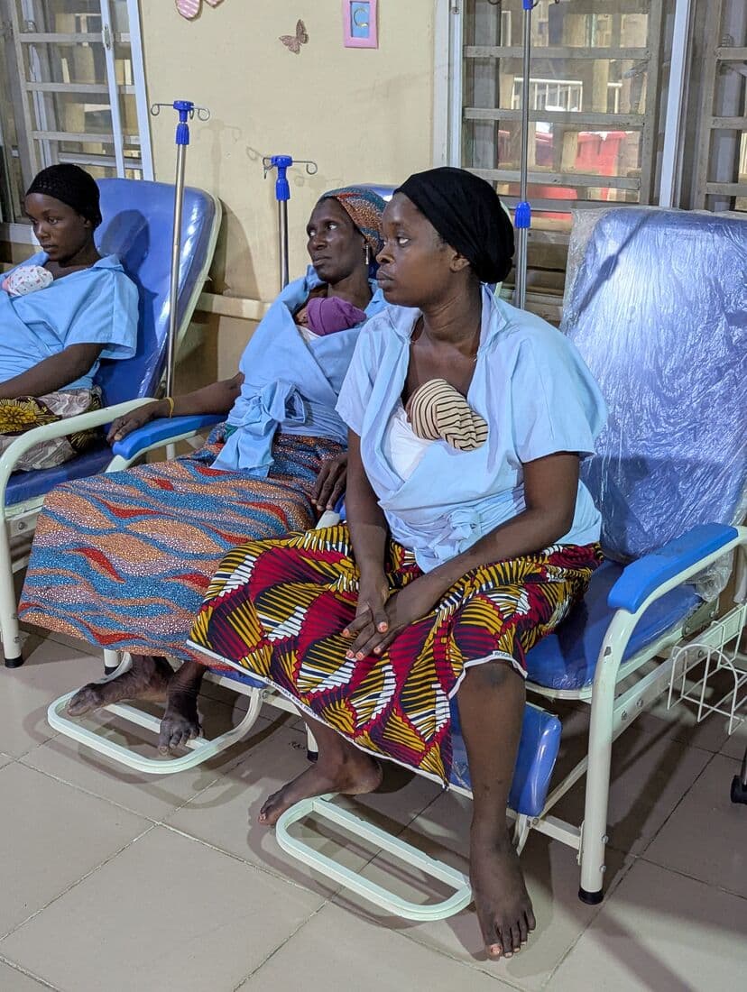 A mother in a Kangaroo Care chair with her newborn held against her chest