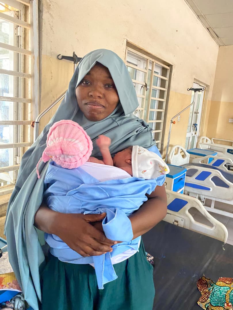 A mother holding her newborn in Kangaroo Care on a ward in Kano